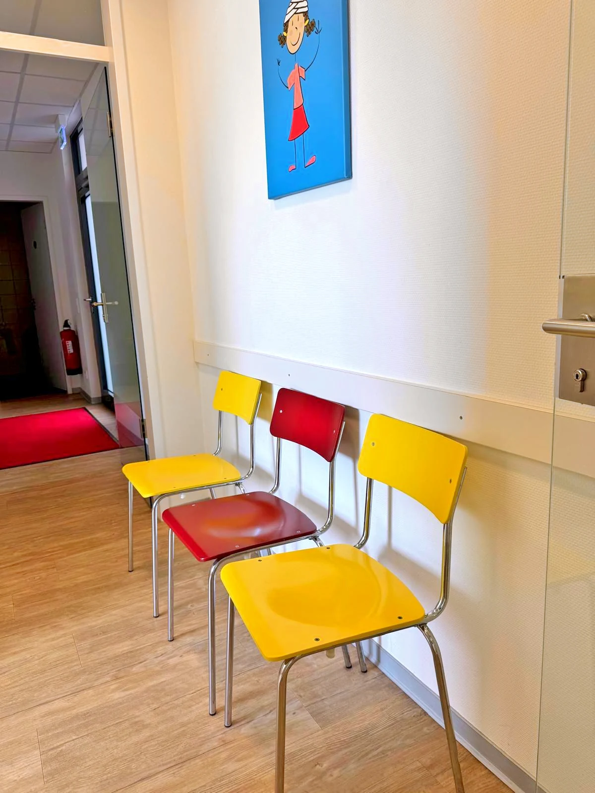 Wartebereich mit gelben und roten Kinderstühlen in der Kinderarztpraxis in Lünen