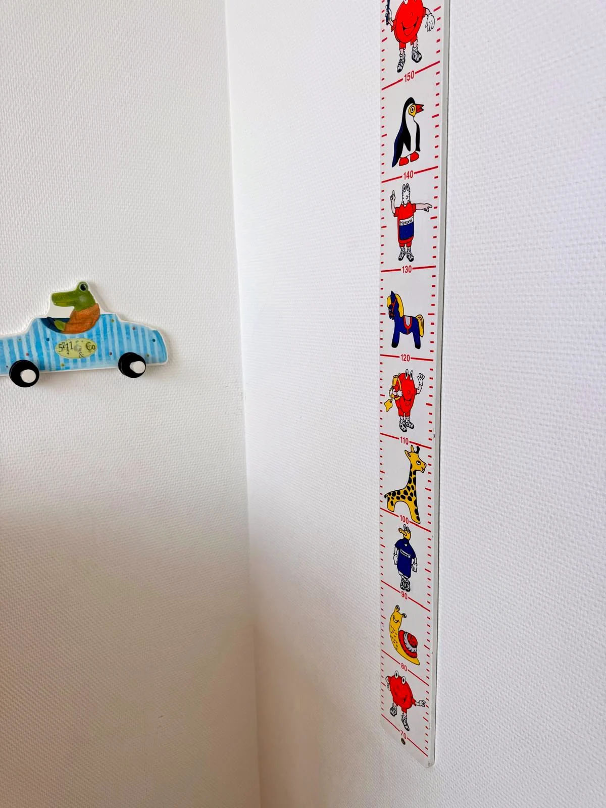 Messlatte mit Tiermotiven und Garderobenhaken im Behandlungsraum