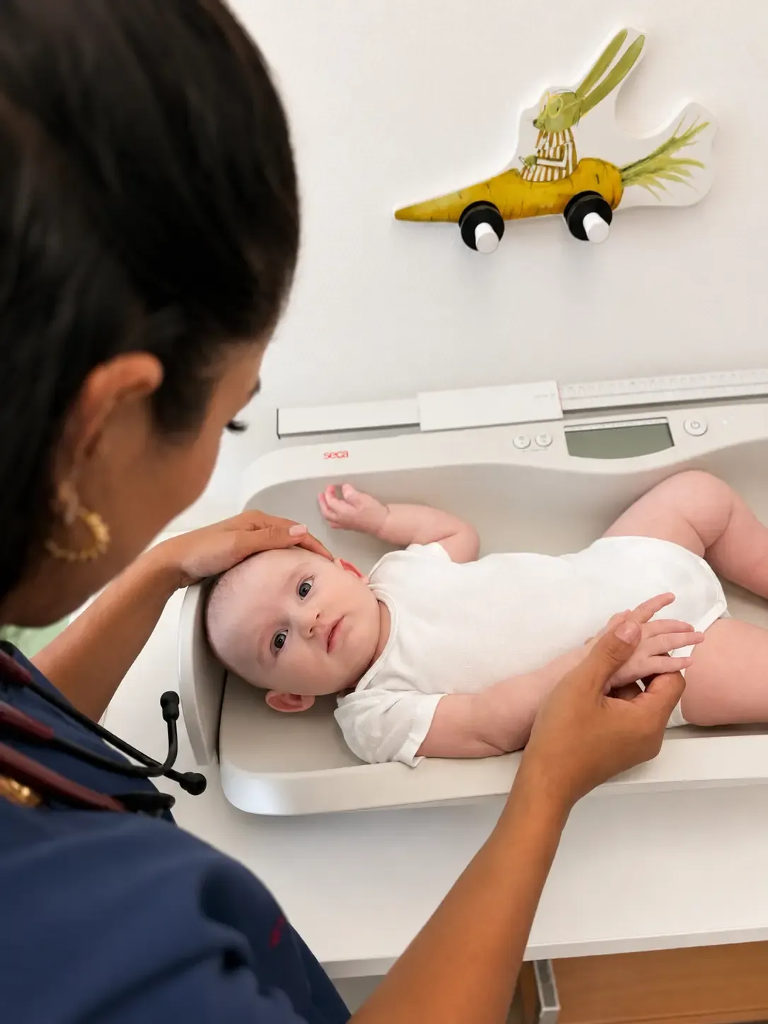 Baby wird auf der Säuglingswaage gewogen und gemessen