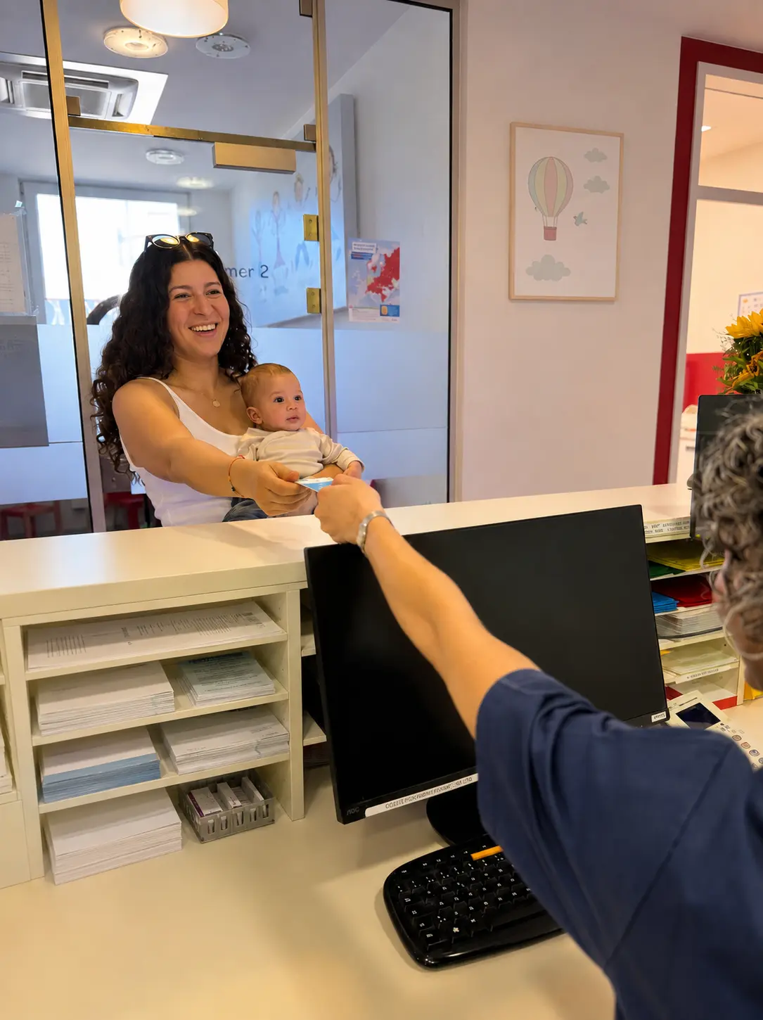 Mutter mit Baby am Empfang der Kinderarztpraxis in der Mersch in Lünen
